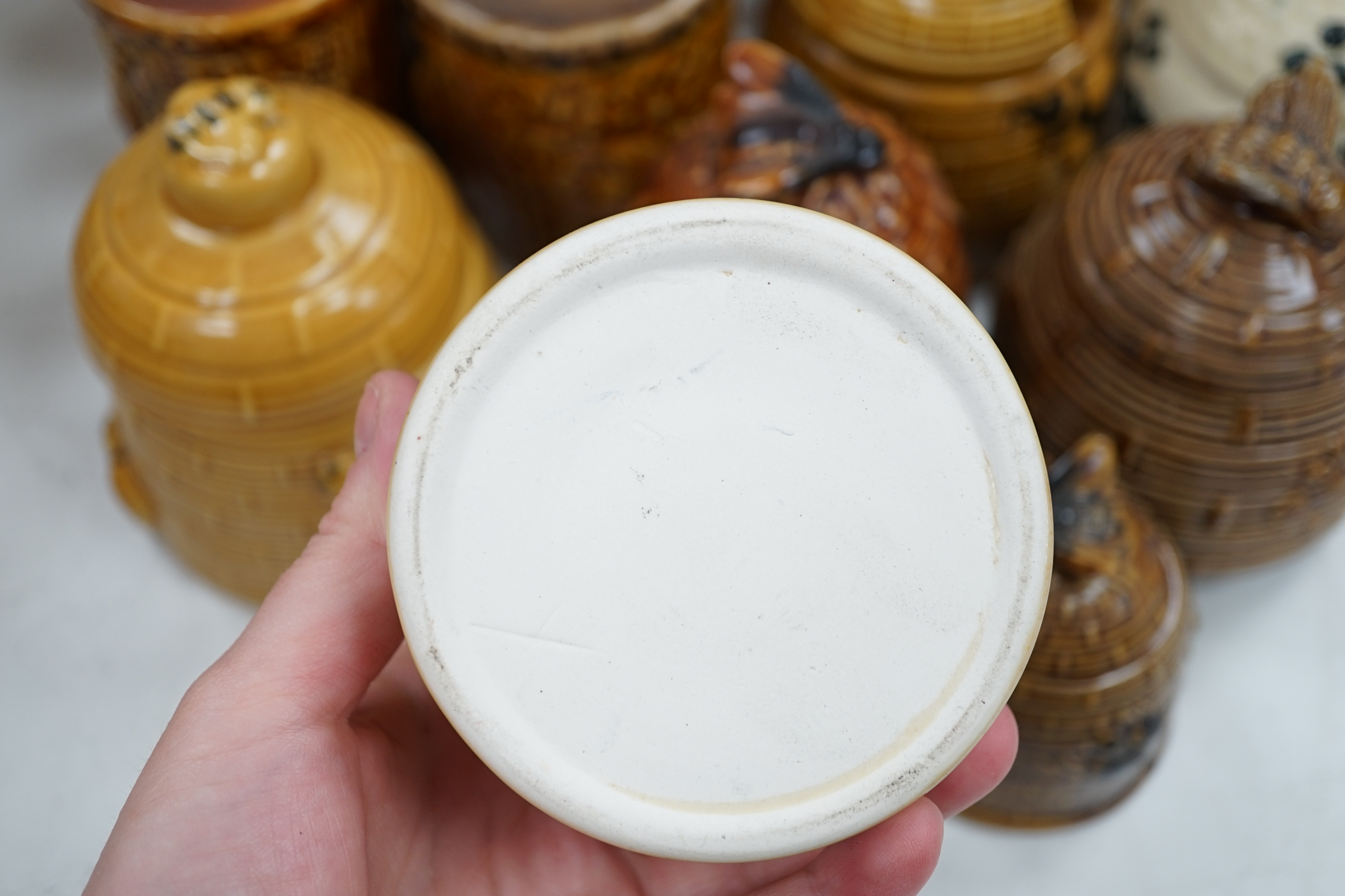 Thirteen various pottery honey jars and covers